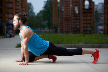 Fototapeta premium Athlete at the city park warming and stretching