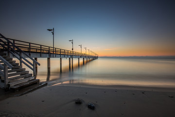 Obraz premium Wooden pier in Mechelinki. Small fishing village in Poland. Amazing Sunrise at the beach