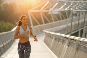 Young woman running in the city on summer morning.