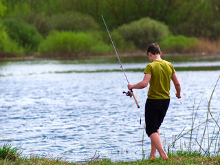 Teenager catches fish on the river