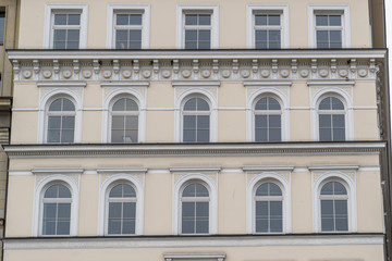 Fototapeta na wymiar Fassade in gelb in der Innenstadt von Hamburg mit Stuck und Fenstern