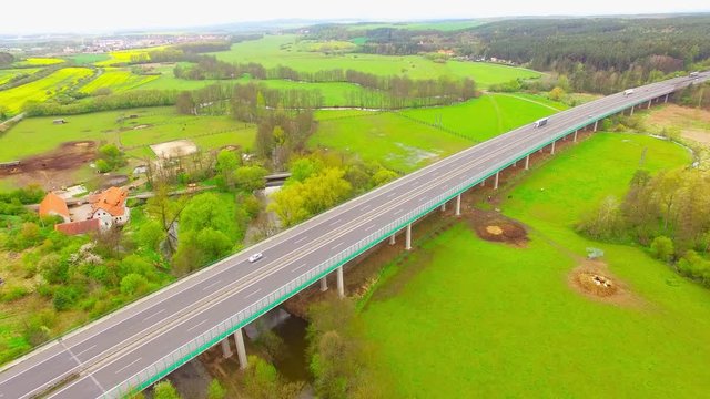 Aerial view of bridge over Radbuza River and green pastures. Highway D5 with traffic near Pilsen, Czech republic, Central Europe. Transportation and sustainable development concept. 