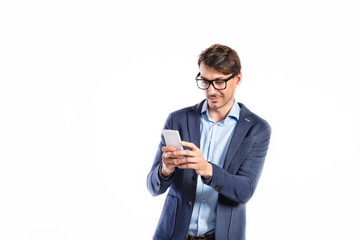 Handsome young man with smart phone. Studio shot, isolated.