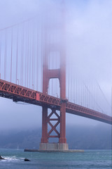 Vertical fog covers the top of the Golden Gate Bridge in San Francisco California