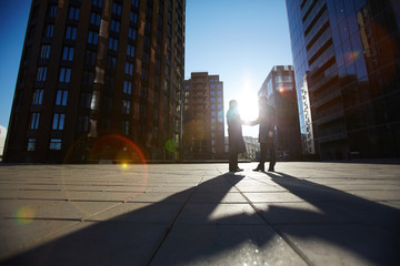 Low angle view of two unrecognizable businessmen shaking hands firmly while standing outdoors, last...