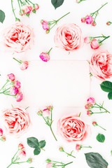 Floral frame made of pink roses, buds and leaves on white background. Flat lay, top view. Floral pattern.
