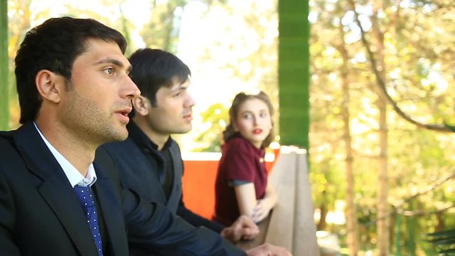 Two Men and a girl in retro style talking to each other on the balcony of the building of 30-40 years