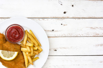 Wiener schnitzel with fried potatoes on white wooden background

