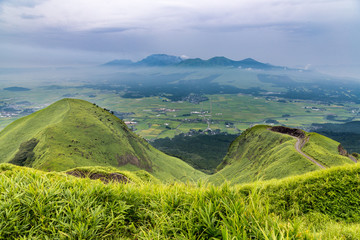 View of Aso volcano mountain and farmer village from hill top in Kumamoto, Kyushu, Japan