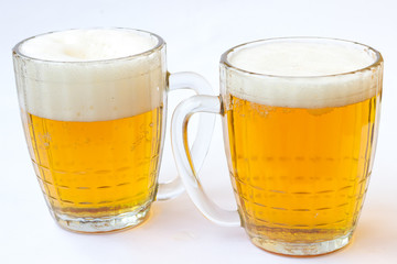 Two mugs of beer on a white background