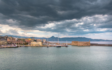 Obraz premium Neoria, old venetian walls of the shipyards at Heraklion with the port and the castle of koule, Crete, Greece.