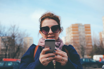 social media addiction - smartphone in woman's hands texting while  walking on the street not being careful