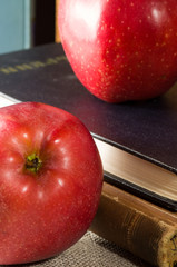 Fragment of old books with hardcover and close-up red apples