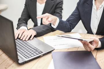 Business woman Hold the pen and pointing screen teaching and discussing Project at Computer notebook and laptop,tablet at Modern Office Environment on Table desk .  business Team strategy as concept.