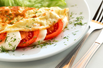Fototapeta na wymiar Tasty italian breakfast omelette with tomato and mozzarella