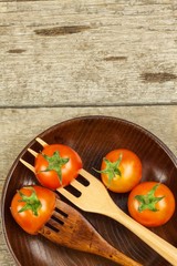 Sherry tomato on a wooden fork. Concept of diet. Vegetarian food. Place for text.