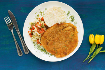 Chicken fillet schnitzel with rice and salad