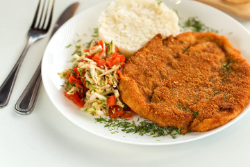 German schnitzel with rice and cabbage salad
