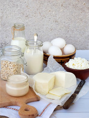 Obraz na płótnie Canvas Set of fresh dairy products on wooden background: milk, cheese cottage, yogurt egg, mozzarella ryazhenka, feta.