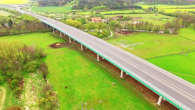 Aerial view of bridge over Radbuza River and green pastures. Highway D5 with traffic near Pilsen, Czech republic, Central Europe. Transportation and sustainable development concept. 