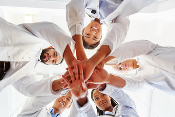 Multikulturelles Ärzte Team stapelt Hände