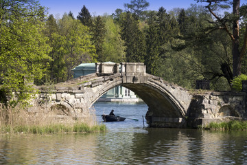 Fototapeta na wymiar The ancient destroyed bridge in the former palace park. Gatchina. Petersburg. Russia...