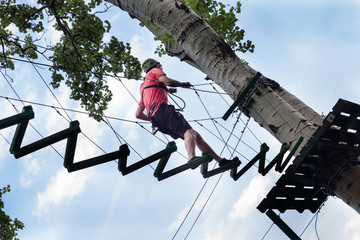man in adventure park on  tree top