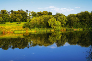 Fototapeta na wymiar Summer countryside reflection in a calm still lake