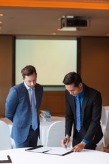 Two Serious Adult Business Men Signing Document