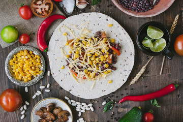 Vegetables, beans and cheese over tortilla bread - vegetarian mexican salad tacos.