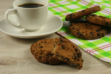 Coffee cup with oatmeal cookie chocolate on wooden background