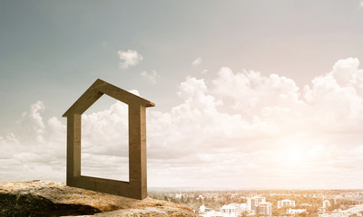 Conceptual image of concrete home sign on hill and natural lands