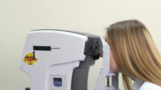 Checking the Eyes of a Woman on a Keratometer