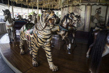 Obraz na płótnie Canvas Vintage restored carousel hand carved wooden tiger on a merry go round ride