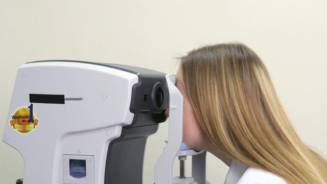 Checking the Eyes of a Woman on a Keratometer