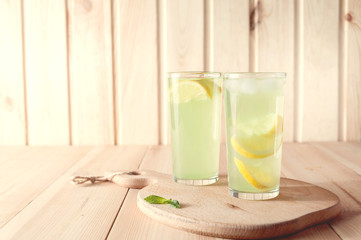 Citrus lemonade water with lemon sliced , healthy and detox water drink in summer on wooden table . vintage color tone