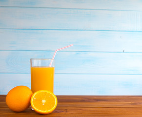 Orange juice in a glass on a wooden background. Fresh fruit from summer