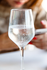 Glasses of mineral water with gas on the background of the girl with the phone.