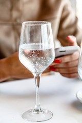 Glasses of mineral water with gas on the background of the girl with the phone.