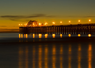 Fototapeta na wymiar Sunset at Oceanside California pier showing the resturant at the end of the pier.