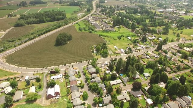 Aerial footage flying over suburban neighborhood towards a farm