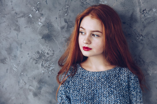 Portrait of cute beautiful young girl with freckles and red hair close-up. Sensitive red lips.