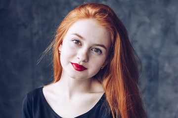 Portrait of cute beautiful young girl with freckles and red hair close-up. Sensitive red lips.