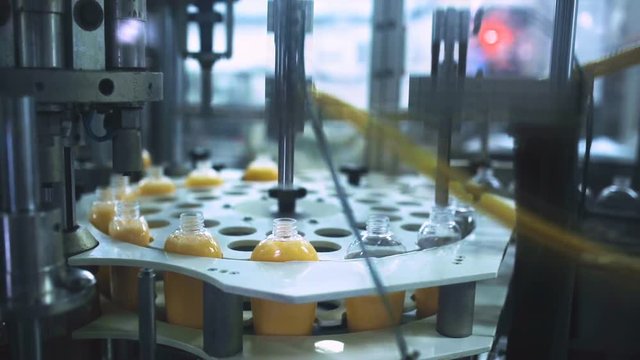 Packaging machine / process of packaging liquid soap in a modern factory / Line of packaging at a cosmetic plant / Plastic containers on a packaging line at a cosmetic factory / Industrial equipment