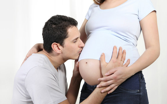 Husband father kissing to her pregnant wife's belly