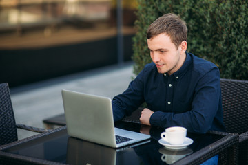 The young bank employee works on a laptop at lunchtime.