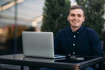 The young bank employee works on a laptop at lunchtime.