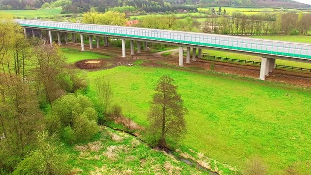 Aerial view of bridge over Radbuza River and green pastures. Highway D5 with traffic near Pilsen, Czech republic, Central Europe. Transportation and sustainable development concept. 