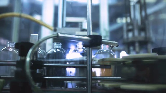 Packaging machine / process of packaging liquid soap in a modern factory / Line of packaging at a cosmetic plant / Plastic containers on a packaging line at a cosmetic factory / Industrial equipment