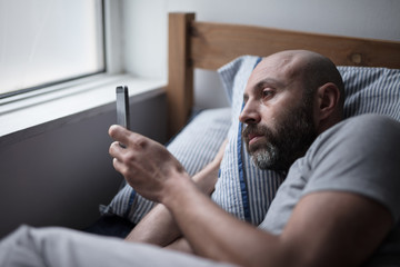 Mid forties depressed man in bed at home